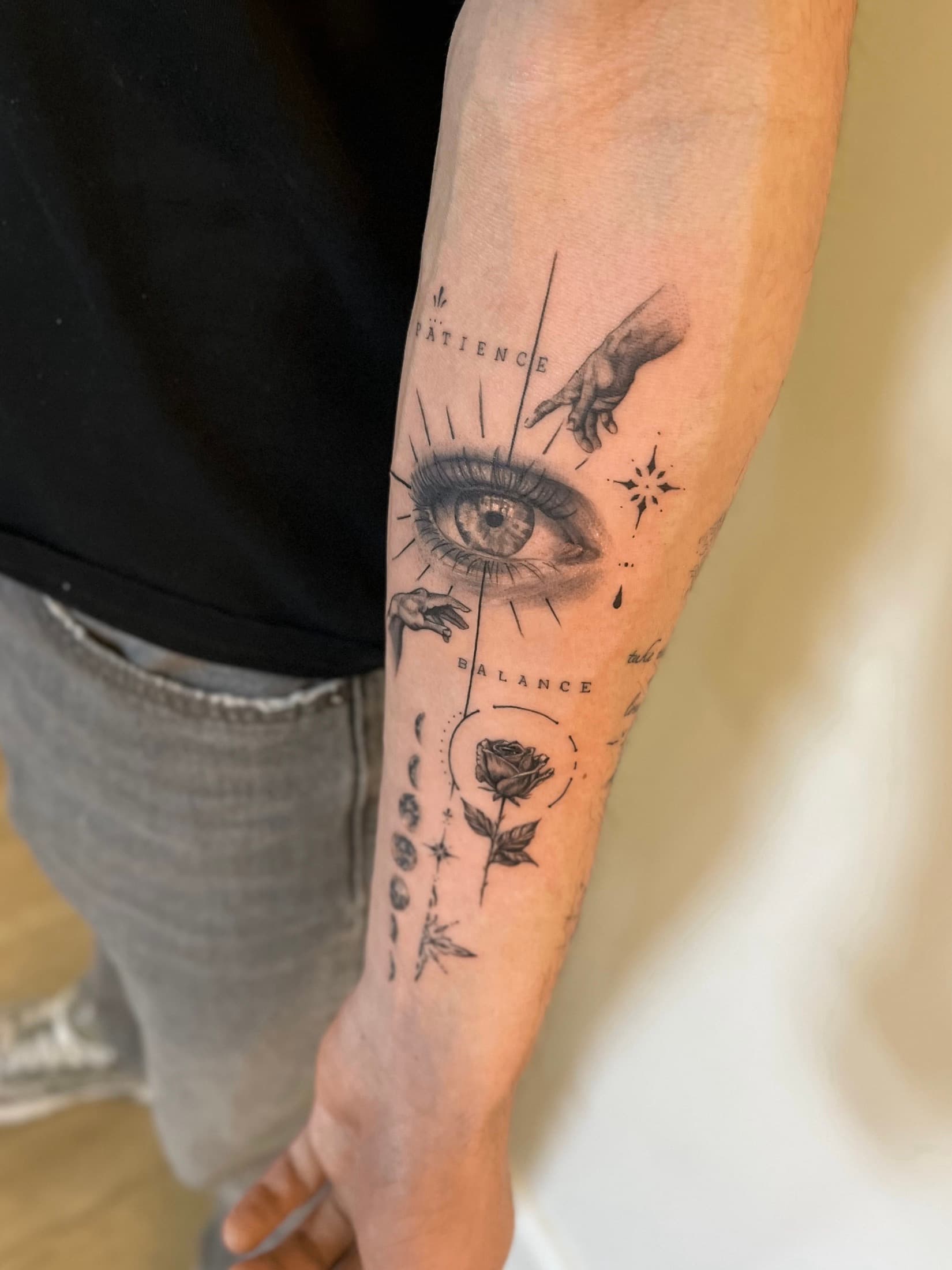 Forearm tattoo with an eye, hands and a rose