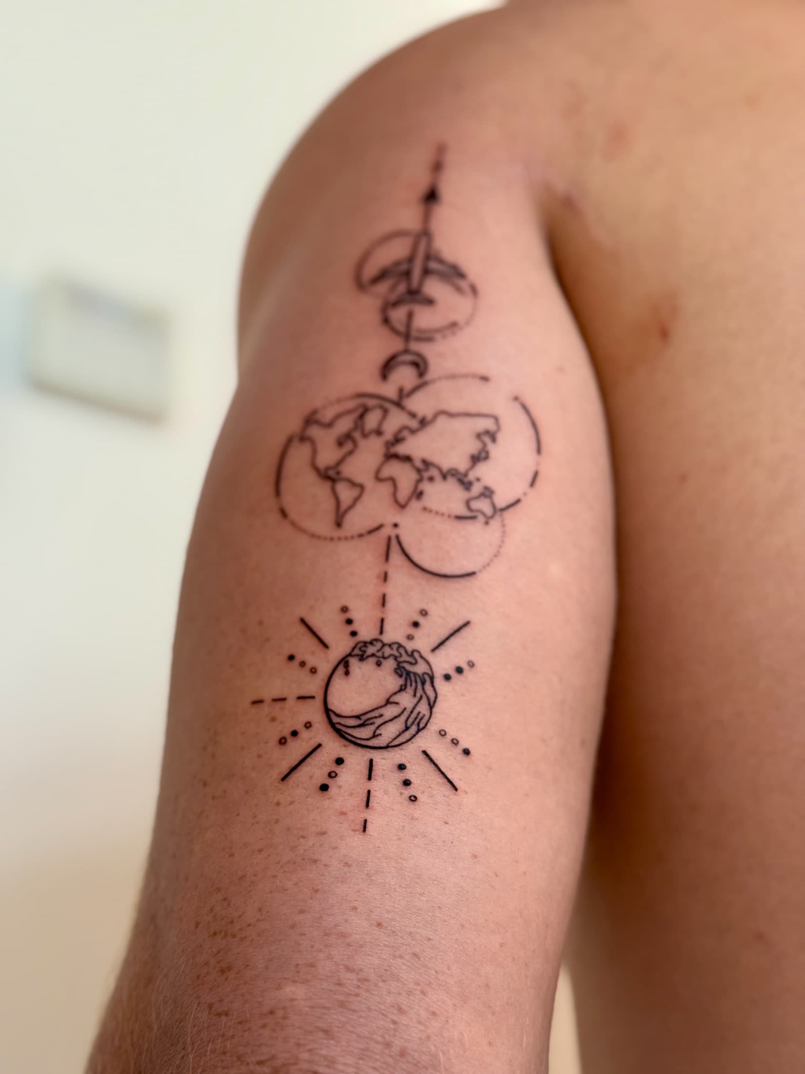 Fineline tattoo with a world map, wave and aeroplane