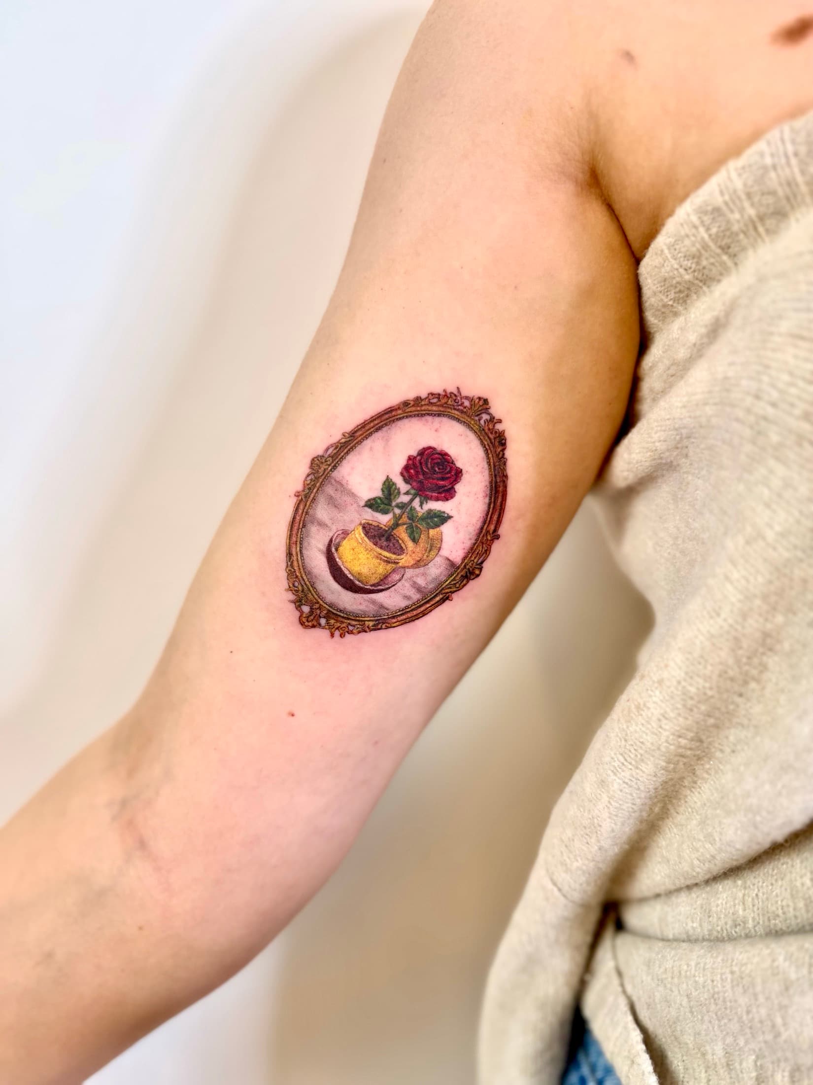 Color rose tattoo in an ornamental frame